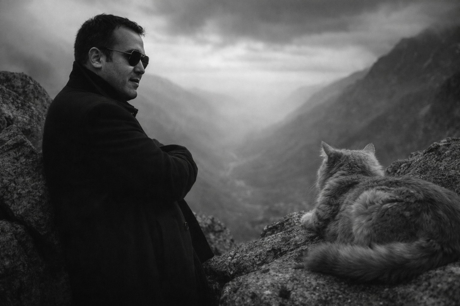 Michael T. Murphy on a mountainside with his cat, overlooking a misty valley — moody grayscale photograph